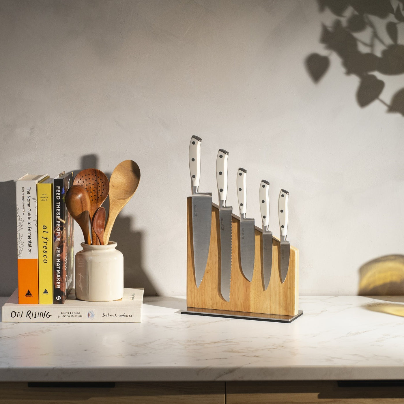 white magnetic block set on counter with books and utensils