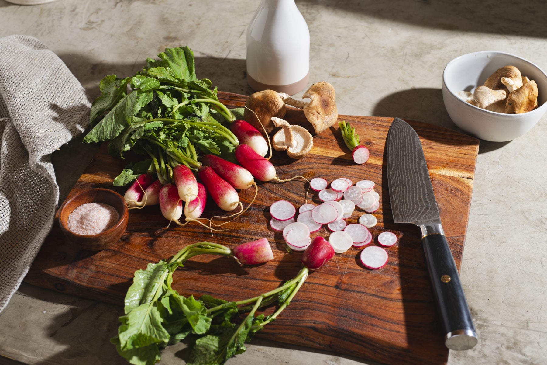 Damascus Chef knife on cutting board with radishes