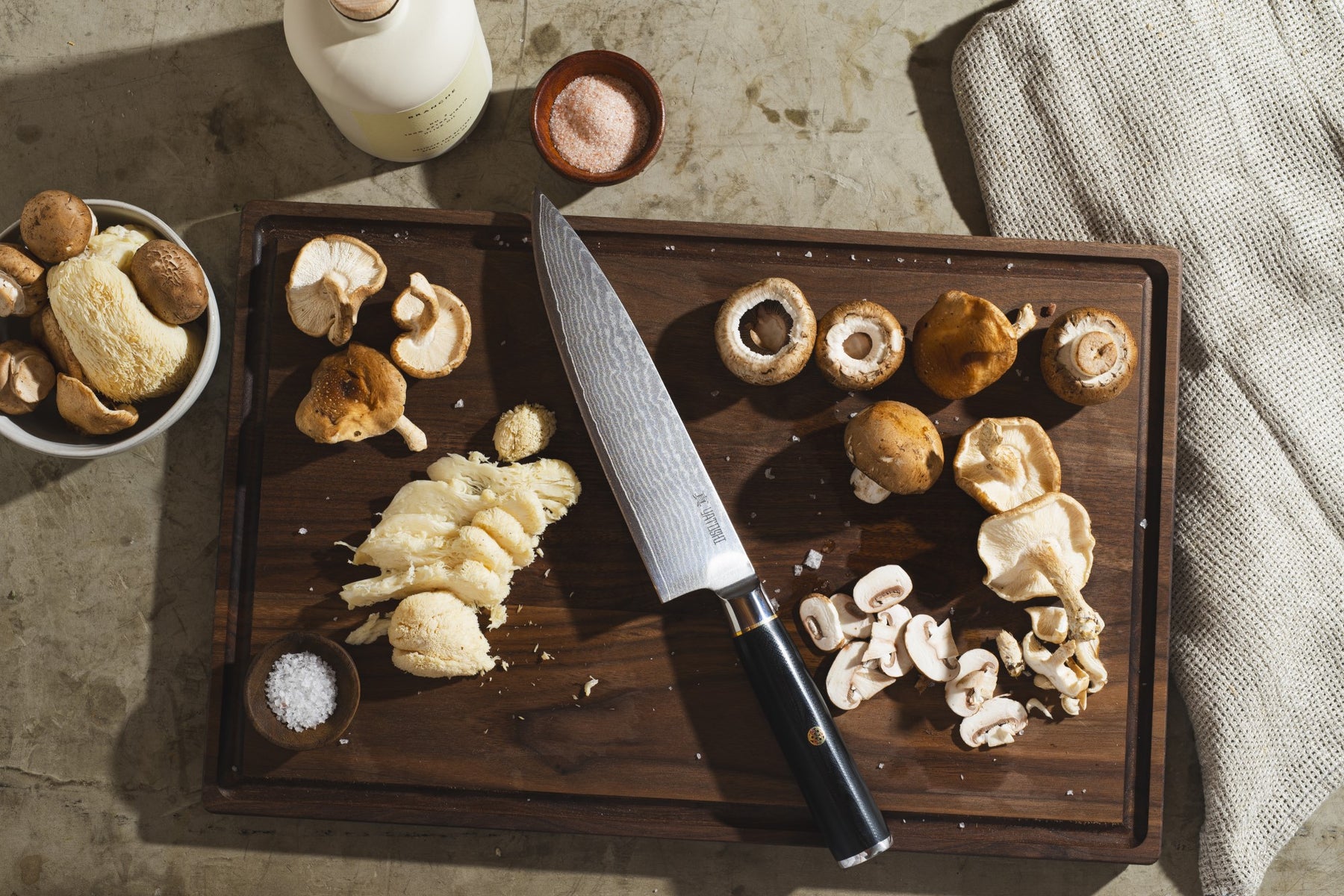 Damascus Chef knife on a cutting board with mushrooms
