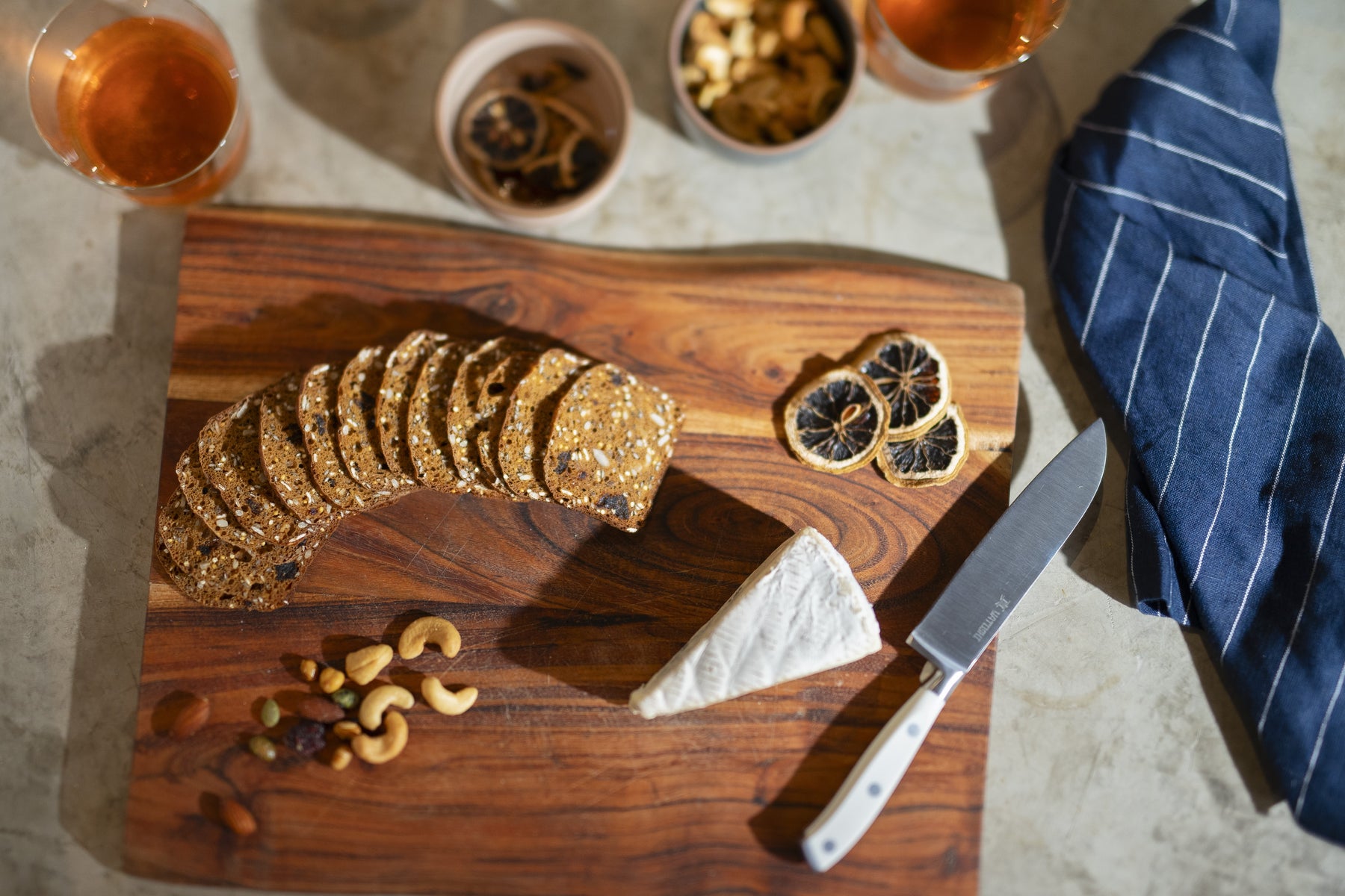White ABS santoku knife on cutting board with cheese and crackers