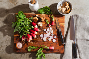 Dark Brown Paring and Chef knife on a cutting board with radishes