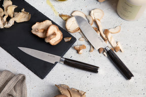 dark brown santoku and paring knife with mushrooms